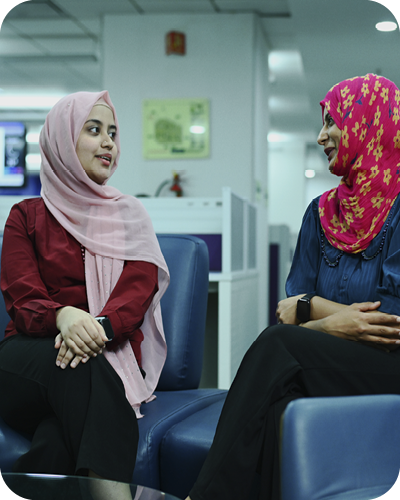 2 colleagues wearing headscarves having conversation