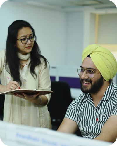 2 colleagues working and chatting at desk
